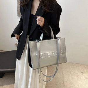 Minimalist silver metallic tote bag with embossed letters for autumn fashion and commuting