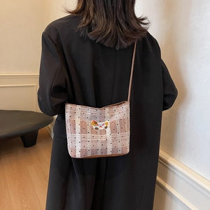 Chic checkered shoulder bag with puppy embroidery and leather strap in a casual setting