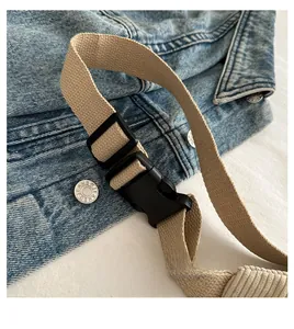Close-up of adjustable beige canvas strap with durable black plastic buckle for chest bag