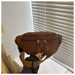 Détail d'un sac banane en velours côtelé marron avec poches zippées et texture nervurée