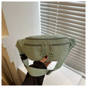 Détail du sac banane en velours côtelé vert clair avec double zip et boucle ajustable
