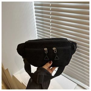 Détail du sac de poitrine en velours côtelé noir avec zips métalliques et bandoulière