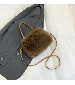 Détail d'un sac bandoulière en fausse fourrure marron avec bandoulière en cuir