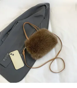 Détail du sac bandoulière en peluche marron avec bandoulière et téléphone pour taille