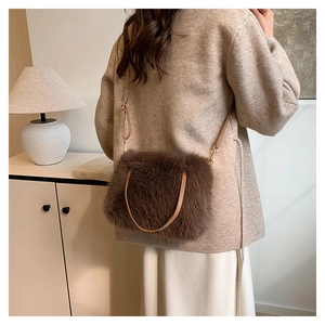Sac bandoulière en fausse fourrure marron foncé porté par un mannequin dans un salon
