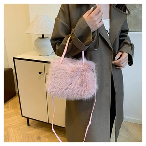 Détail du sac à main en fausse fourrure rose montrant la texture douce et la bandoulière