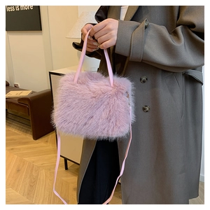 Détail du sac à main en fausse fourrure rose clair montrant la texture douce et la sangle