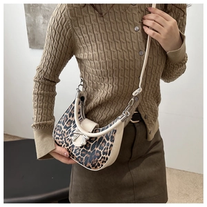 Détail du sac demi-lune imprimé léopard avec nœud argenté et bandoulière réglable