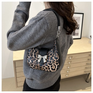 Détail d'un sac hobo à imprimé léopard avec boucle nœud argenté porté à l'épaule