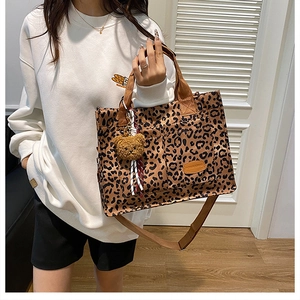Detail of leopard print tote bag with bear charm and adjustable shoulder strap