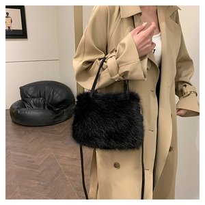 Détail d'un sac à main en fausse fourrure noire avec poignées en cuir sur un mannequin chic