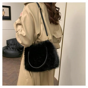 Détail de la texture en fausse fourrure noire et de la bandoulière en cuir du petit sac