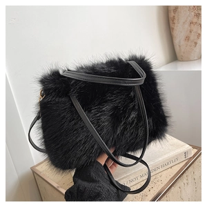 Gros plan d'un sac cabas en fausse fourrure noire sur socle montrant la texture douce et l'anse