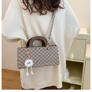 Détail du sac bandoulière à carreaux avec motif vintage et joli pendentif en peluche