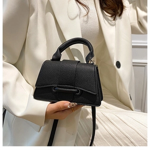 Close-up of black lychee grain leather mini bag with unique double ring buckle detail