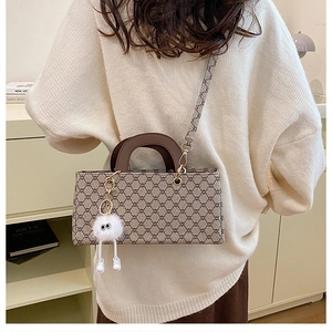 Détail du sac à main rétro à motif géométrique avec breloque monstre en peluche douce