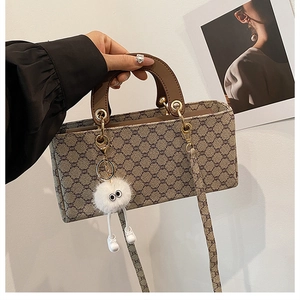Vue détaillée du sac bandoulière vintage avec breloque en peluche et boucles dorées