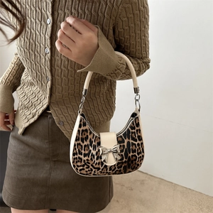 Sac hobo imprimé léopard avec boucle nœud argenté porté à l'épaule par un mannequin