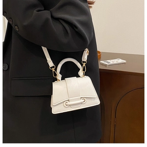 Detailed close-up of white lychee-patterned mini handbag with gold metal hardware and strap