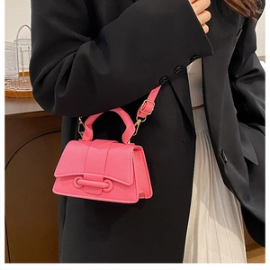 Close-up of pink litchi grain leather mini crossbody bag with ring buckle on a model