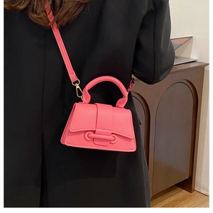 Close-up of bright pink mini trapezoid crossbody bag with gold-tone hardware detail