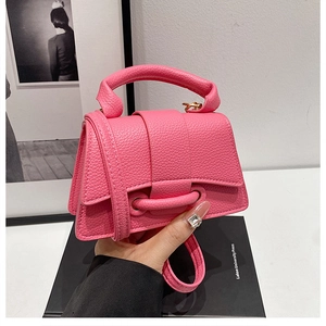 Handheld magenta pebbled leather mini crossbody bag with round handle and flap closure