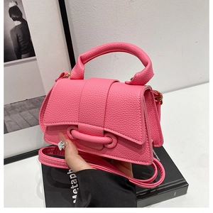 Detailed macro view of Barbie pink lychee texture leather handbag with gold hardware