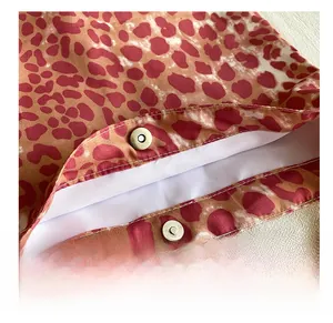 Close-up of red leopard print canvas bag featuring silver magnetic snap closures