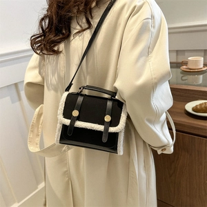 Chic women's crossbody bag in black leather with white faux fur trim for autumn fashion