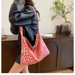 Pink leopard print hobo bag in soft canvas fabric shown on a model's shoulder