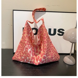 Macro detail of high-capacity pink leopard print canvas tote bag on an aesthetic desk