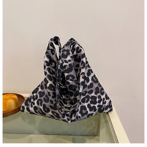 Close-up of leopard print canvas tote bag showing soft drape and wide shoulder strap