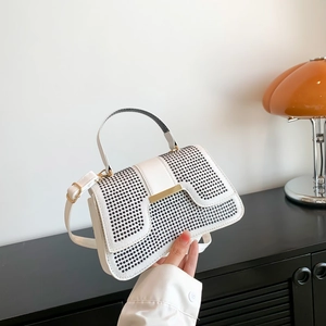 Schicke weiße Handtasche mit schwarzen Perlen und goldenen Beschlägen im modernen Stil