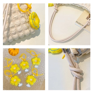 Detail shots of off-white quilted shoulder bag with daisy charm and knotted strap