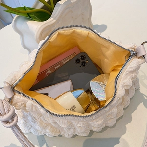 Detailed macro view of the white puckered fabric handbag showing bright yellow lining space