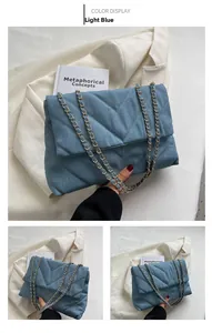 Détail du sac en denim matelassé bleu clair avec coutures en V et chaîne dorée