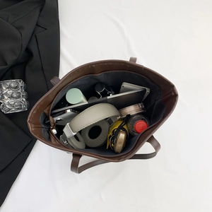 Top view of large brown tote bag showing spacious interior with tablet and daily essentials
