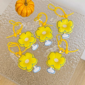 Detail of colorful plush flower charms with yellow coils and acrylic chain on glass