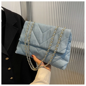 Détail du sac chaîne en jean bleu clair avec matelassage en V et chaîne dorée
