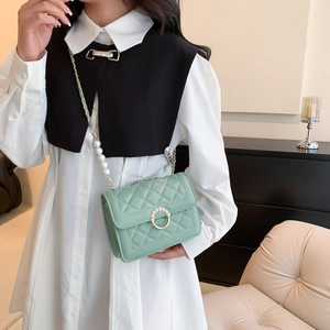 Sac bandoulière vert menthe matelassé avec boucle perle et chaîne sur un modèle