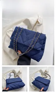 Détails du sac bandoulière en denim bleu marine avec matelassage chevron et chaîne dorée