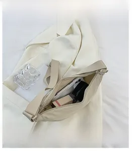 Top view of beige nylon crescent bag interior showing large storage for phone and lipstick