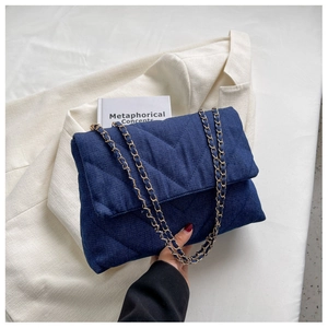 Détail du sac à chaîne en denim bleu foncé avec surpiqûres en V et garnitures dorées