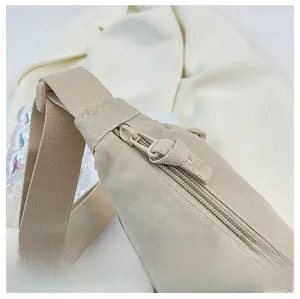 Close-up of smooth zipper detail and durable nylon fabric on beige crescent shoulder bag