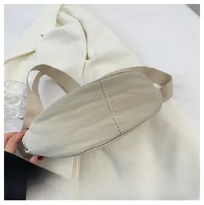 Detail view of the beige nylon moon bag showing high-quality double stitching and texture