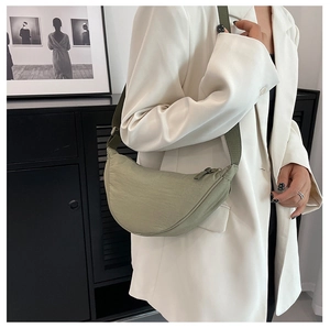 Detail of sage green nylon crescent bag with adjustable wide strap and zipper closure