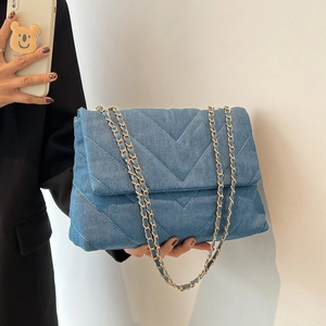 Sac à main matelassé en denim bleu avec coutures en V et bandoulière chaîne dorée