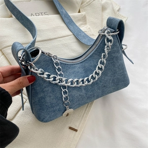 Detail of blue denim hobo bag with chunky silver chain strap and zipper closure