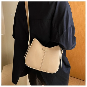Detail of minimalist beige crossbody bag with fashion tag and vertical stitching texture
