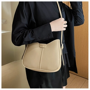 Detailed view of beige leather crossbody bag with vertical stitching and fashion buckle